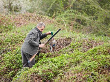 Bir ördek tutan çift namlulu av tüfeği ile Hunter