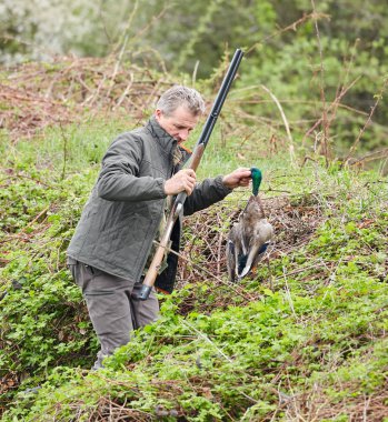 Bir ördek tutan çift namlulu av tüfeği ile Hunter