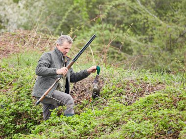 Bir ördek tutan çift namlulu av tüfeği ile Hunter