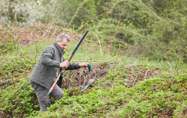 Bir ördek tutan çift namlulu av tüfeği ile Hunter