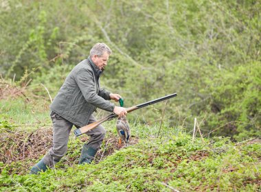 Bir ördek tutan çift namlulu av tüfeği ile Hunter