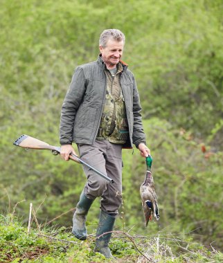 Bir ördek tutan çift namlulu av tüfeği ile Hunter