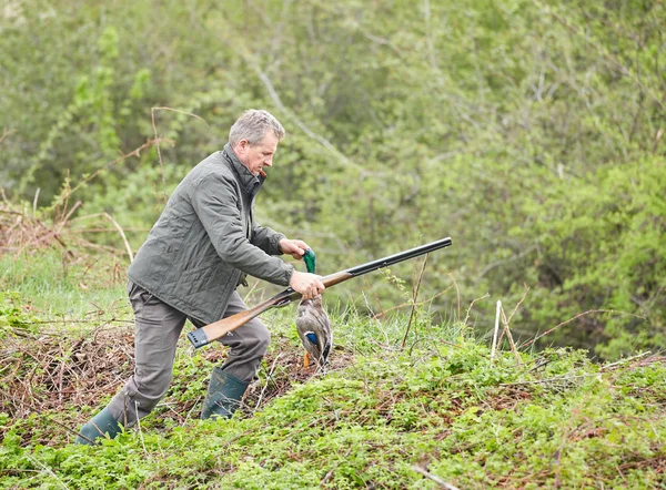 Bir ördek tutan çift namlulu av tüfeği ile Hunter
