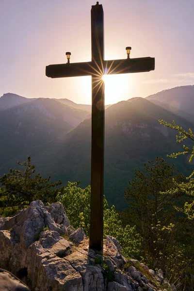 Landscape from mountain peak with cross sign at sunset