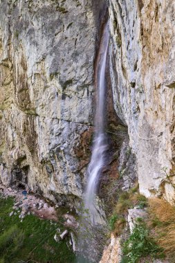 Dikey bir uçurum üzerinde dağlarda Şelale