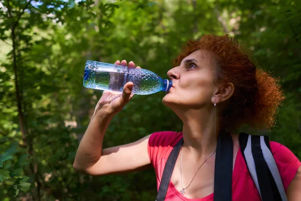 長いハイキングの後にバックパック飲料水を持つアクティブな女性 — ストック写真