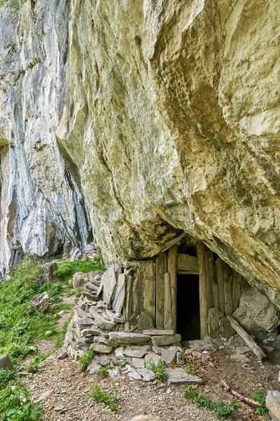 Primitive mountain shelter built under rock face