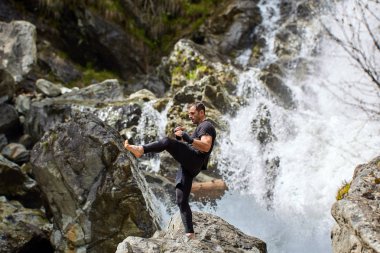 Güçlü bir şelale tarafından gölge boks ile bir muay tay veya kickboxer eğitim
