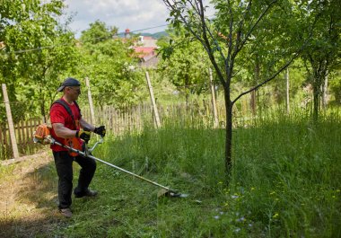 Çimlerini çim kesiciyle biçen adam