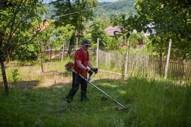 Çimlerini çim kesiciyle biçen adam