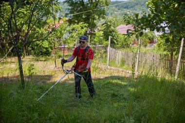 Çimlerini çim kesiciyle biçen adam