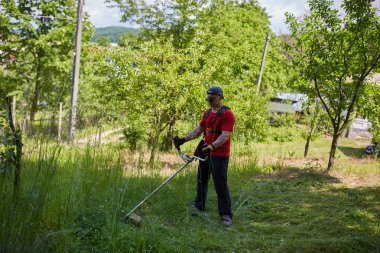 Çimlerini çim kesiciyle biçen adam