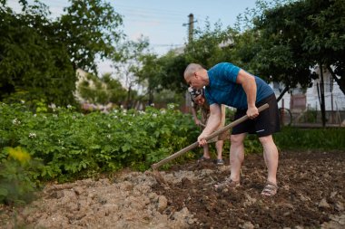 Bahçede çalışan yaşlı anne ve oğul çiftçiler