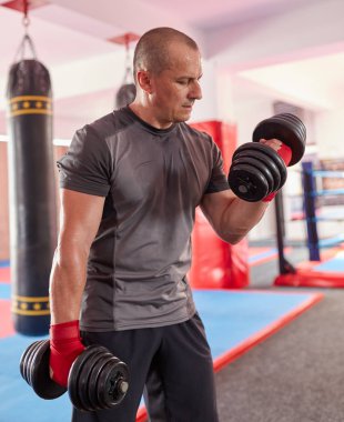 Spor salonunda ağırlıkları ile sarılmış elleri ile Boxer eğitim