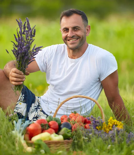 Ευτυχισμένος Αγρότης Κάθεται Στο Γρασίδι Ένα Καλάθι Από Διάφορα Λαχανικά — Φωτογραφία Αρχείου