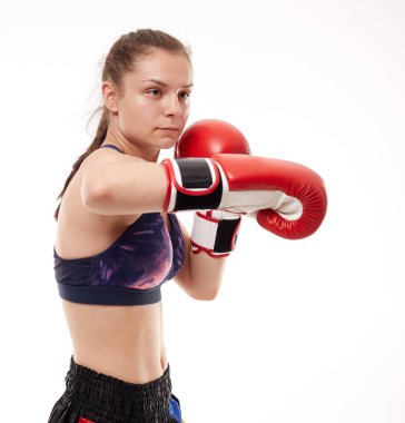 Genç kız kickboks eğitimi almış, beyaz arka planda izole edilmiş.