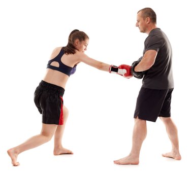 Kız kickboks dövüşçüsü koçuyla yumruk tokuşturuyor, beyaz arka planda izole edilmiş.