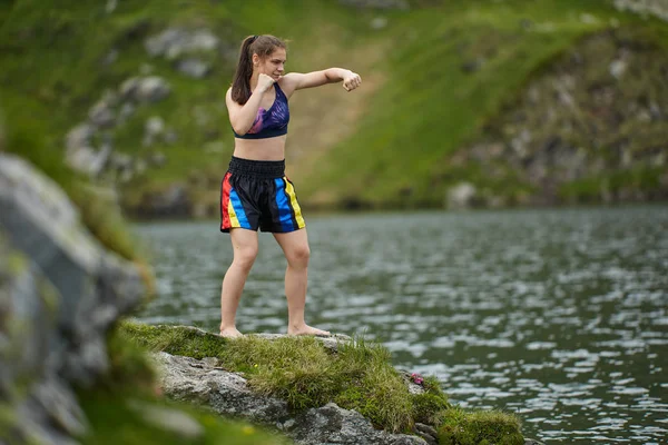 拳击手女孩训练湖在山在白天 — 图库照片
