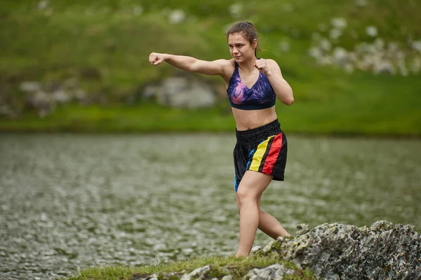 拳击手女孩训练湖在山在白天 — 图库照片