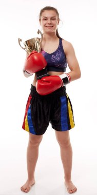 Kickboks müsabakasının mutlu kızı, altın kupayı tutuyor.