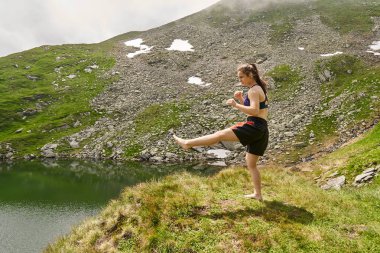 Dağlarda bir göl tarafından Kickboxer kız eğitim