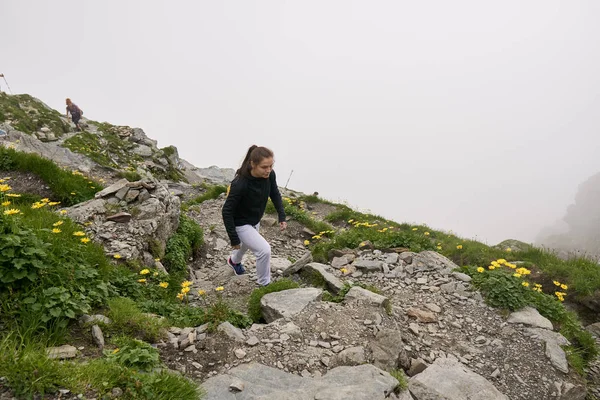 背着背包在岩石山上的小径上徒步旅行的女人 — 图库照片