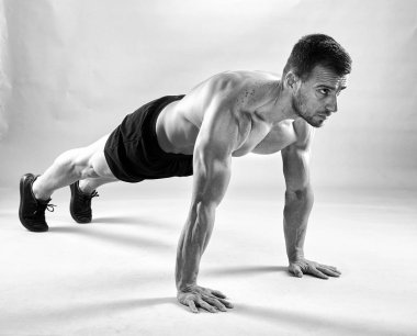 Studio gri arka plan üzerinde şınav fitness modeli