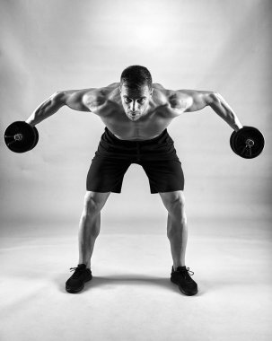 Gri zemin üzerine ağırlıklar ile çalışma dışarı fitness modeli