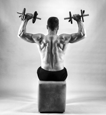 Gri zemin üzerine ağırlıklar ile çalışma dışarı fitness modeli