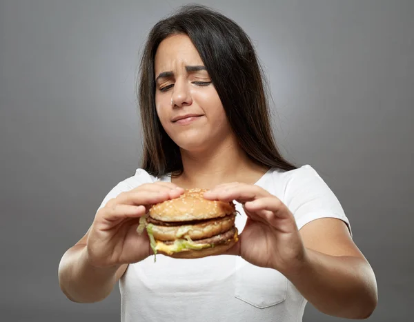 Mulher Comendo Hambúrguer Fast Food Insalubre Fundo Cinza — Fotografia de Stock