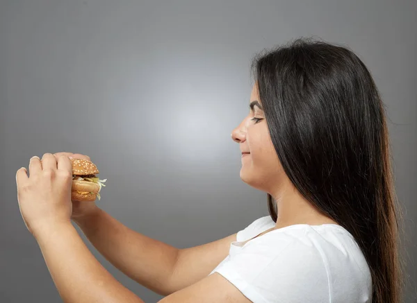Mulher Comendo Hambúrguer Fast Food Insalubre Fundo Cinza — Fotografia de Stock