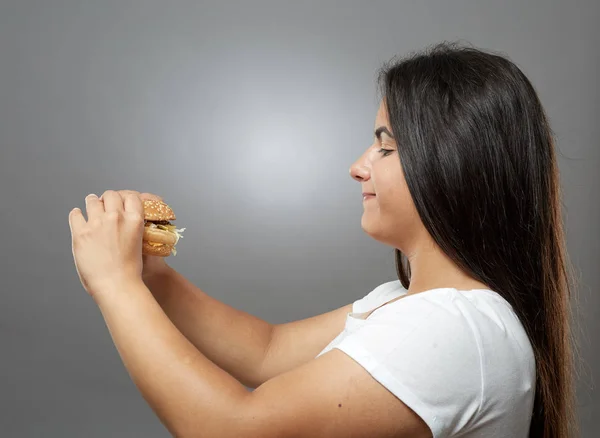 Mujer Comiendo Hamburguesa Comida Rápida Poco Saludable Sobre Fondo Gris — Foto de Stock