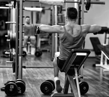 adam yapıyor omuzlarda ve geri egzersiz jimnastik salonu aynanın önünde