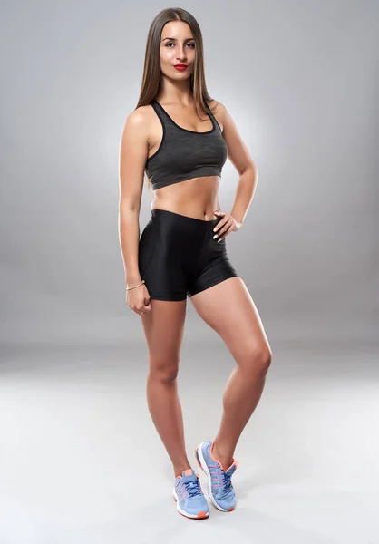 Jonge Atletische Vrouw Poseren Als Fitness Model Grijze Achtergrond — Stockfoto
