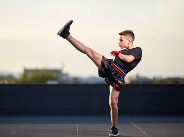 Genç muay-tay savaşçı veya kick-boxer eğitim şehrin üzerinde çatıda