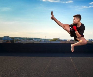 Genç muay-tay savaşçı veya kick-boxer eğitim şehrin üzerinde çatıda