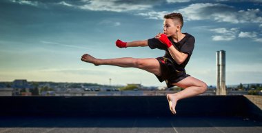 Genç muay-tay savaşçı veya kick-boxer eğitim şehrin üzerinde çatıda