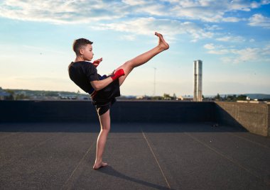 Genç muay-tay savaşçı veya kick-boxer eğitim şehrin üzerinde çatıda