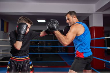 Genç kickbox savaşçı antrenörü ile mitts isabet