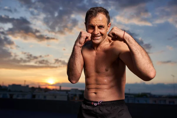 Fighter posing at sunset in guard stance