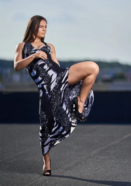Beautiful woman fighter with kickbox moves in an elegant dress