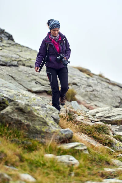 登山道でのカメラハイキングを持つバックパッカーの女性 — ストック写真