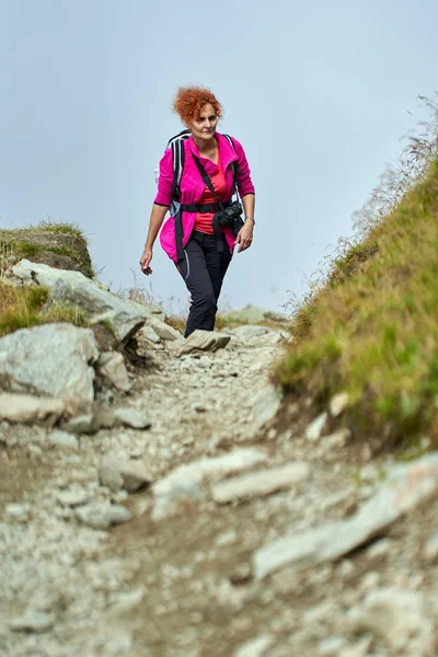 登山道でのカメラハイキングを持つバックパッカーの女性 — ストック写真