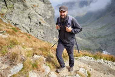 Sırt çantası yla dağ patikası üzerinde yürüyüş adam