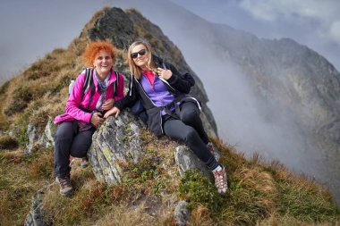 Sırt çantaları bir dağ yolu üzerinde yürüyüş ile iki kadın
