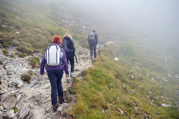一群背着背包在山路上徒步旅行的人 — 图库照片