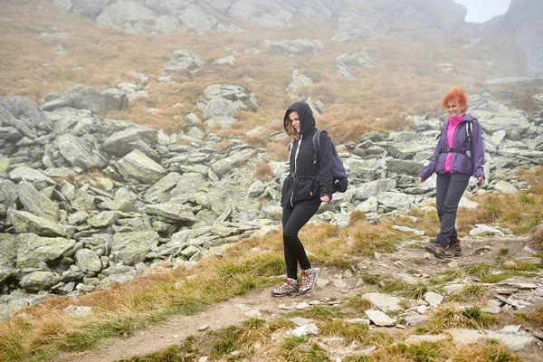 Sırt Çantaları Bir Dağ Yolu Üzerinde Yürüyüş Ile Iki Kadın — Stok fotoğraf