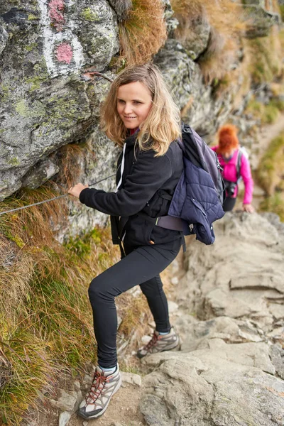 两个背着背包在山路上徒步旅行的妇女 — 图库照片