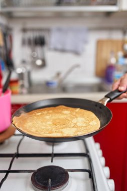 El becerisi ile kızartma tavasında pancake flipping kadın Closeup