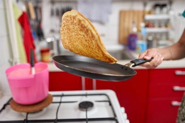 El becerisi ile kızartma tavasında pancake flipping kadın Closeup